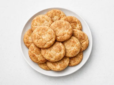 A plate of soft Christmas snickerdoodles coated in cinnamon sugar with crinkled tops