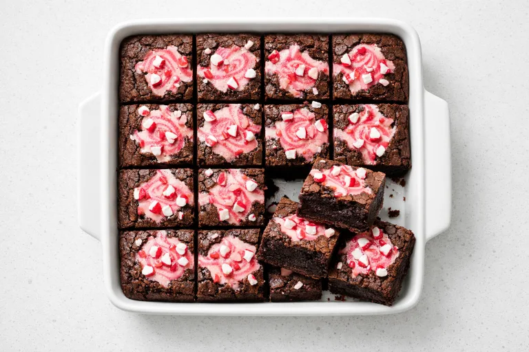 Christmas brownies with peppermint cream cheese swirl and crushed candy canes in a white baking dish