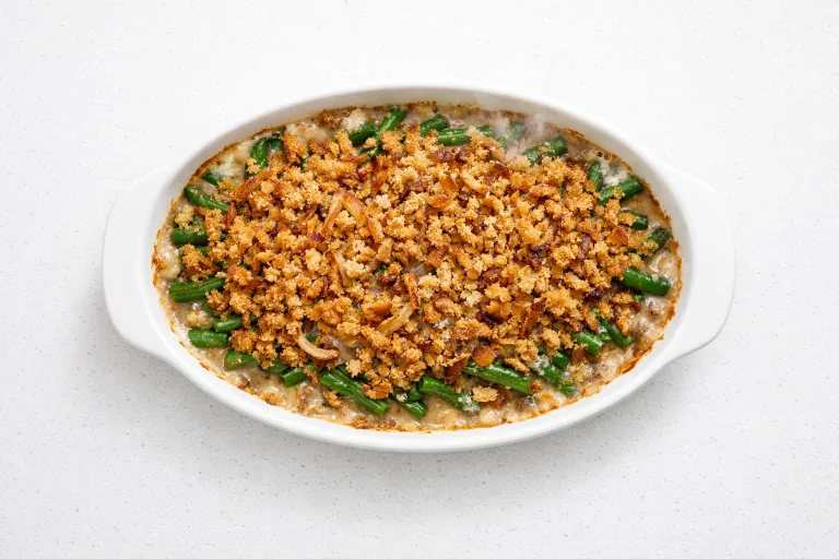 Christmas green bean casserole in a white oval baking dish with crispy shallot topping, fresh from the oven