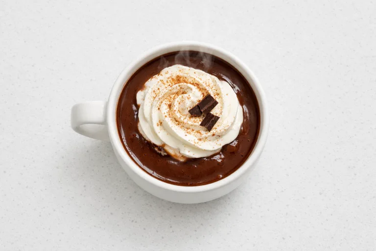 Christmas hot chocolate in a white mug topped with whipped cream and cinnamon