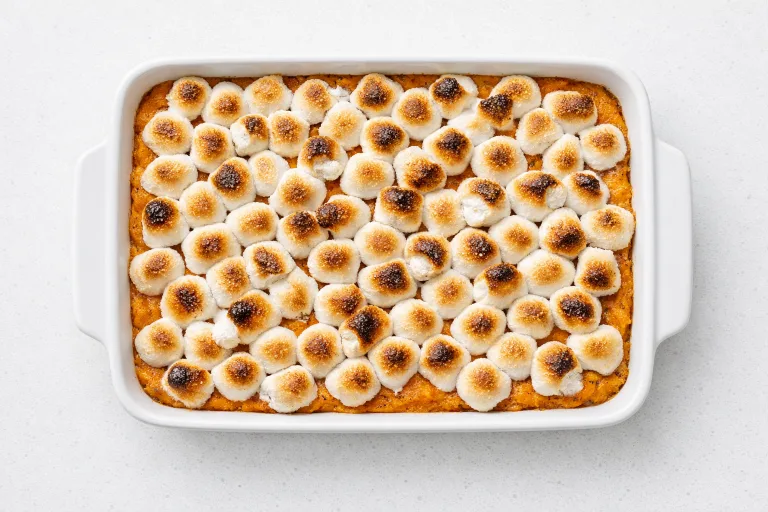 Christmas yams sweet potato casserole with golden toasted marshmallows in a white baking dish