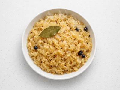 German Christmas sauerkraut with caraway seeds and juniper berries in a white ceramic bowl