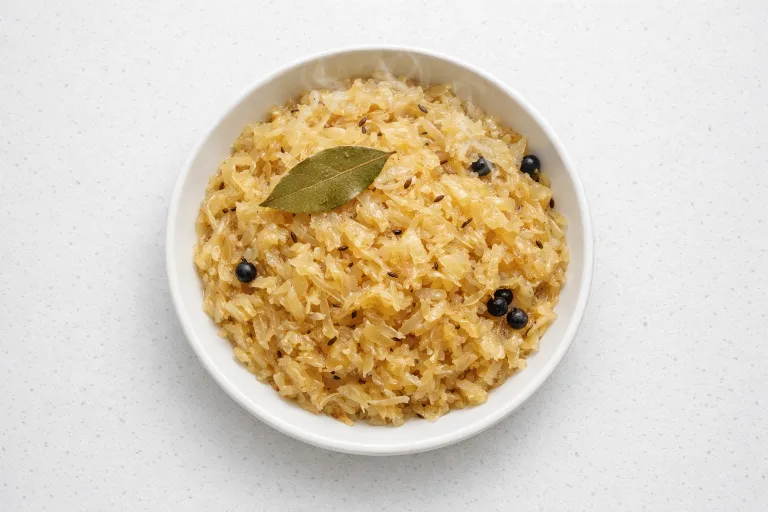 German Christmas sauerkraut with caraway seeds and juniper berries in a white ceramic bowl