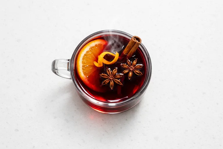 Glass mug of German mulled wine with orange slice, cinnamon stick, and star anise