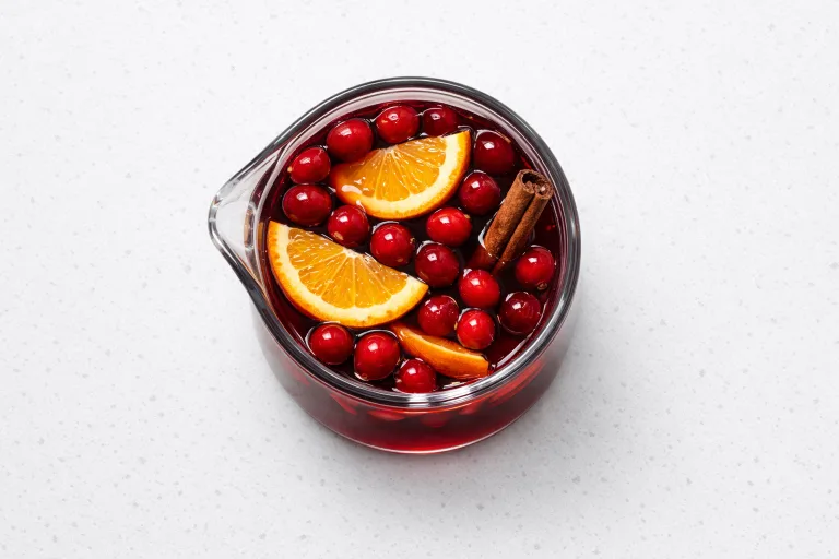 Overhead view of a pitcher of christmas juice made with cranberry, pomegranate, and fresh orange slices